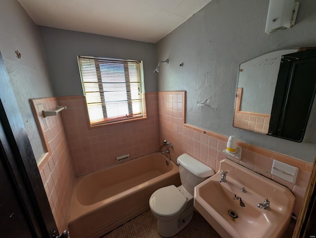 full bath featuring tub / shower combination, toilet, tile walls, and wainscoting