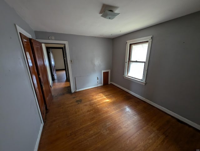 spare room with wood finished floors and baseboards