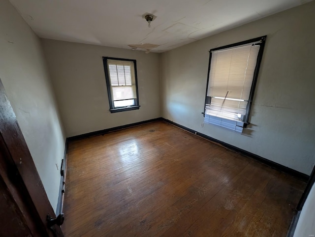 spare room featuring hardwood / wood-style floors and baseboards