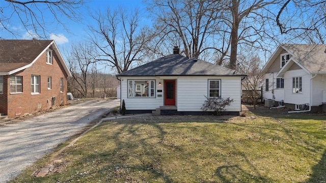 bungalow-style house with a front yard, central AC, driveway, and a chimney