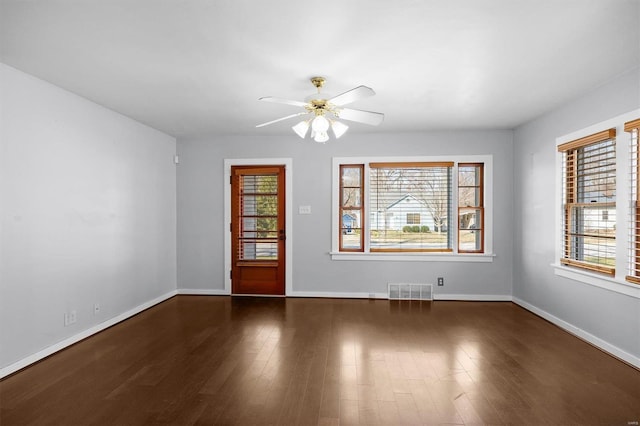 unfurnished room featuring wood finished floors, visible vents, and a wealth of natural light