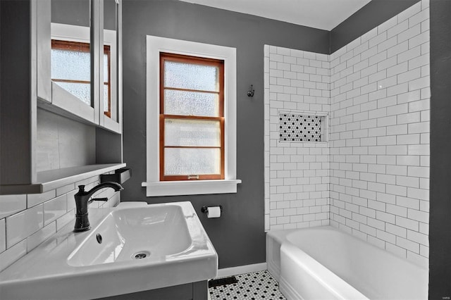 bathroom featuring a sink, baseboards, bathing tub / shower combination, and tile patterned floors