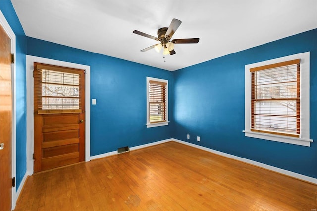 empty room with baseboards, ceiling fan, and hardwood / wood-style floors