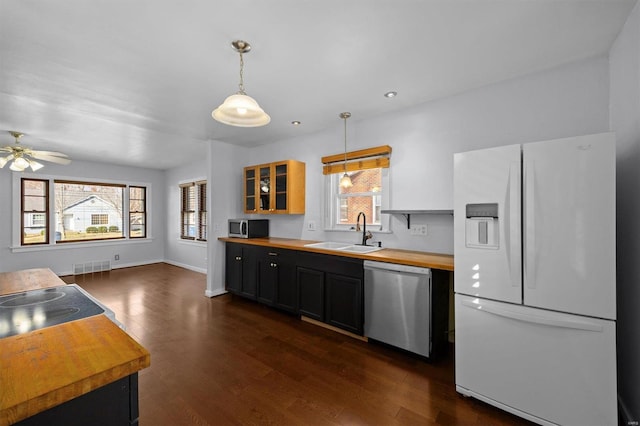 kitchen featuring visible vents, dark wood-type flooring, a sink, appliances with stainless steel finishes, and butcher block counters