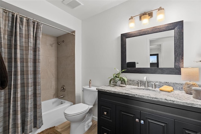 bathroom with vanity, wood finished floors, visible vents, shower / bath combo, and toilet