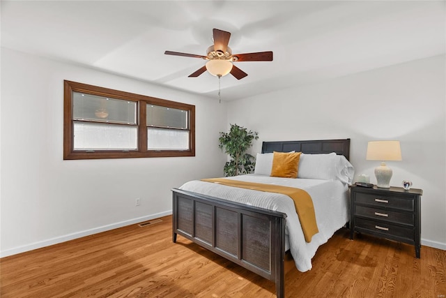 bedroom with visible vents, baseboards, and wood finished floors