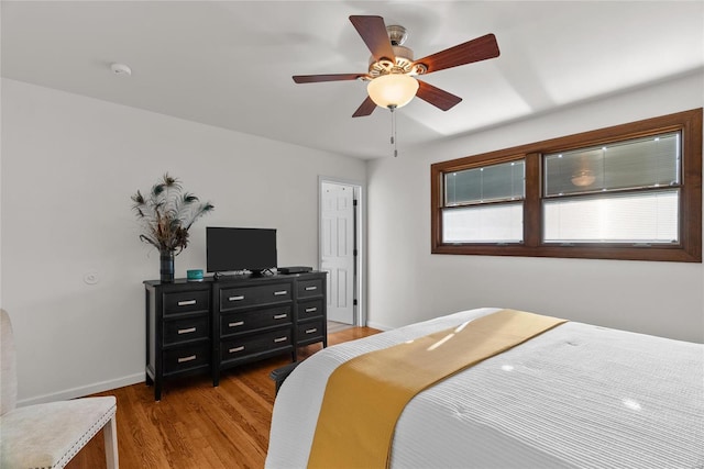 bedroom with light wood-style floors, baseboards, and ceiling fan