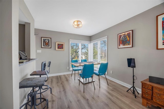 dining area featuring baseboards and wood finished floors