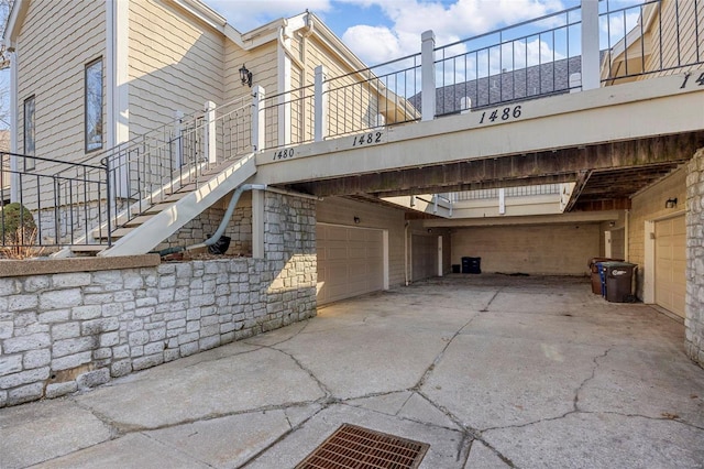 view of side of home with stairway, driveway, and an attached garage