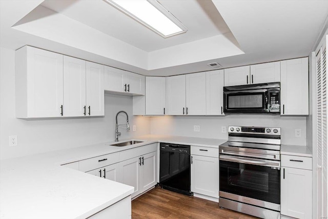 kitchen with white cabinetry, black appliances, light countertops, and a sink