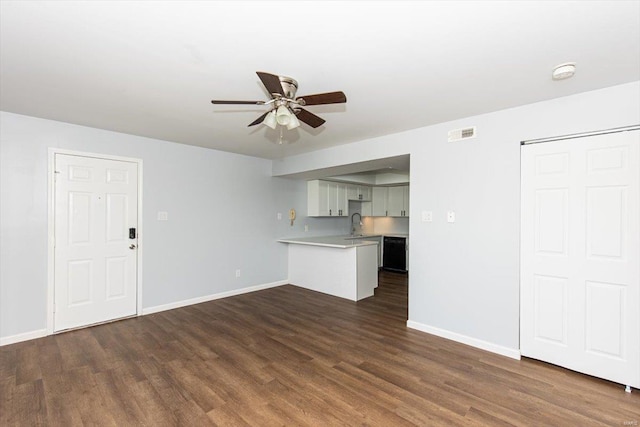 unfurnished living room with dark wood-type flooring, baseboards, visible vents, and ceiling fan