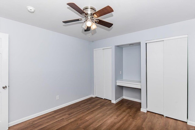 unfurnished bedroom featuring ceiling fan, baseboards, two closets, and wood finished floors