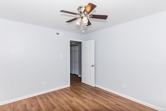 empty room featuring visible vents, ceiling fan, baseboards, and wood finished floors