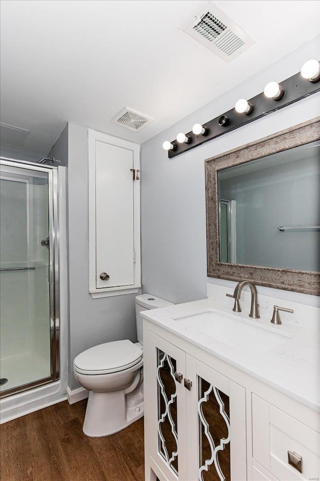 full bath with visible vents, a stall shower, toilet, and wood finished floors