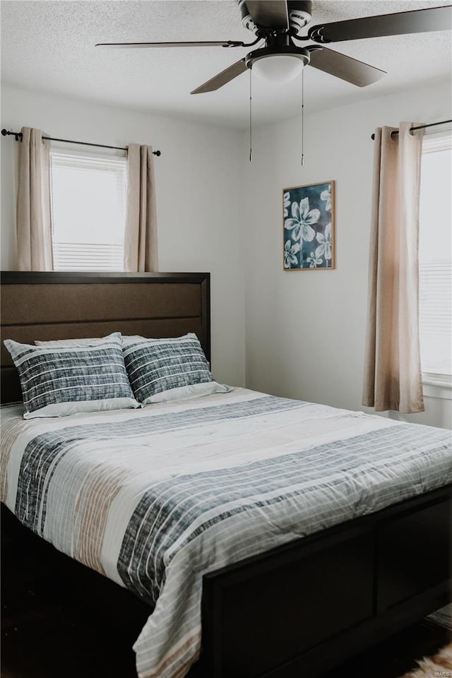 bedroom featuring a textured ceiling and a ceiling fan