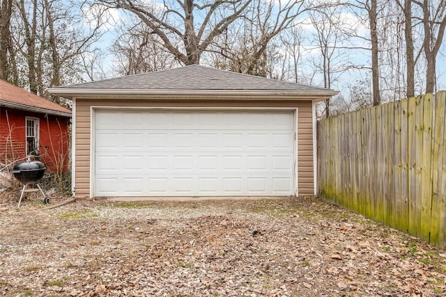 detached garage featuring fence