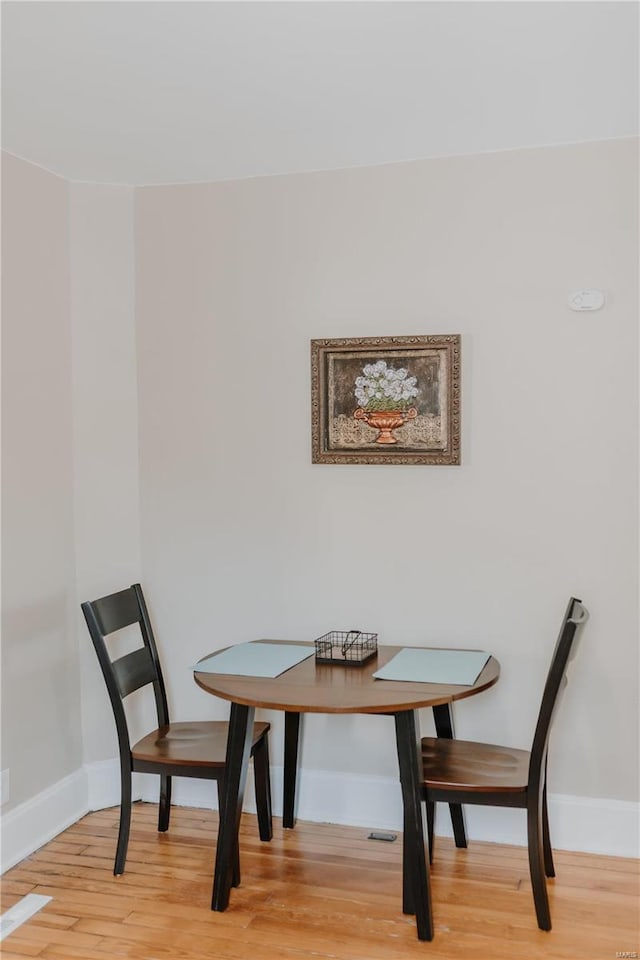 dining space featuring wood finished floors and baseboards