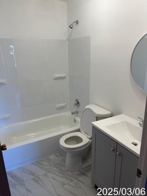 bathroom with marble finish floor, tub / shower combination, vanity, and toilet