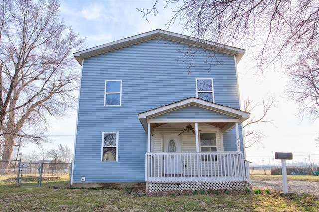 back of property with a porch, a gate, a ceiling fan, and fence