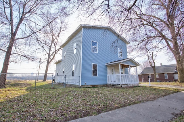 view of front of property with covered porch, fence, a front yard, and a gate