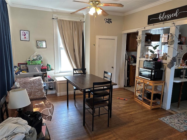 dining room featuring crown molding, wood finished floors, and a ceiling fan