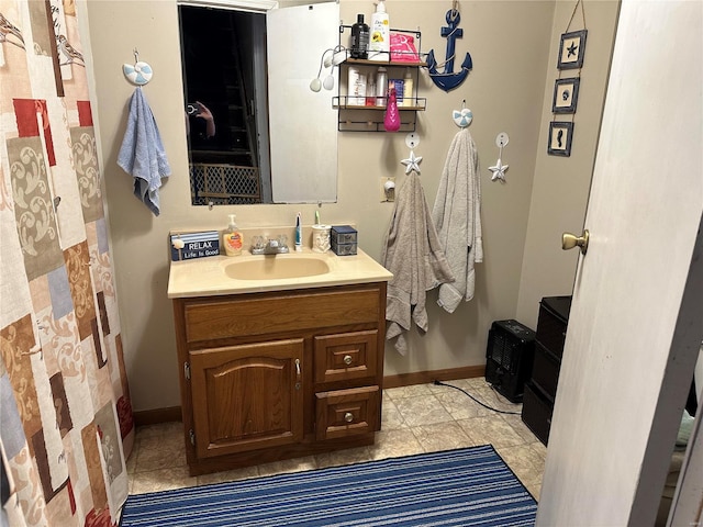 full bath featuring baseboards and vanity