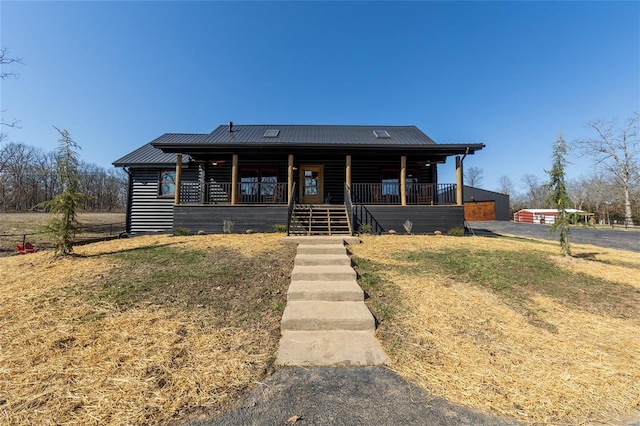 log cabin featuring a porch and metal roof