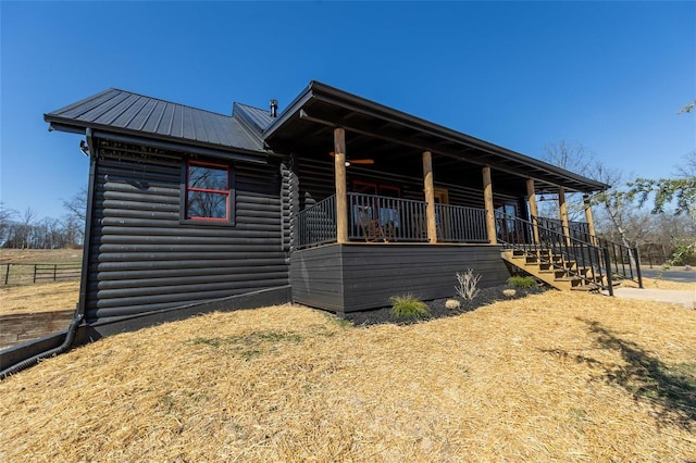 view of side of property with faux log siding, stairway, and metal roof