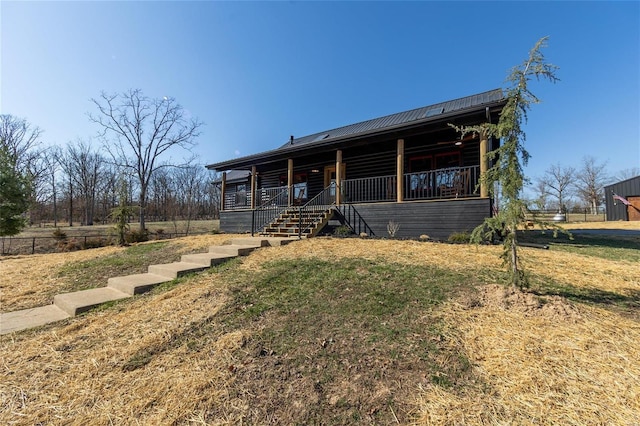 log-style house featuring covered porch and metal roof