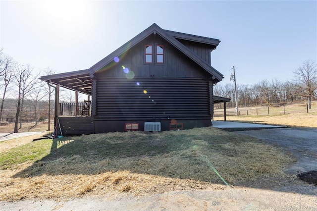 view of side of property featuring log siding, a yard, and fence