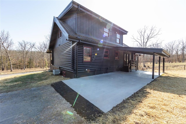 exterior space featuring an attached carport and log siding