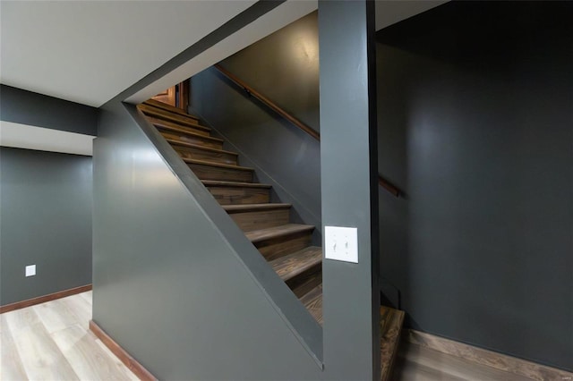 stairway featuring baseboards and wood finished floors