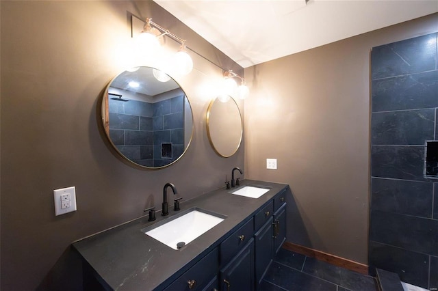 bathroom featuring tile patterned floors, double vanity, baseboards, and a sink