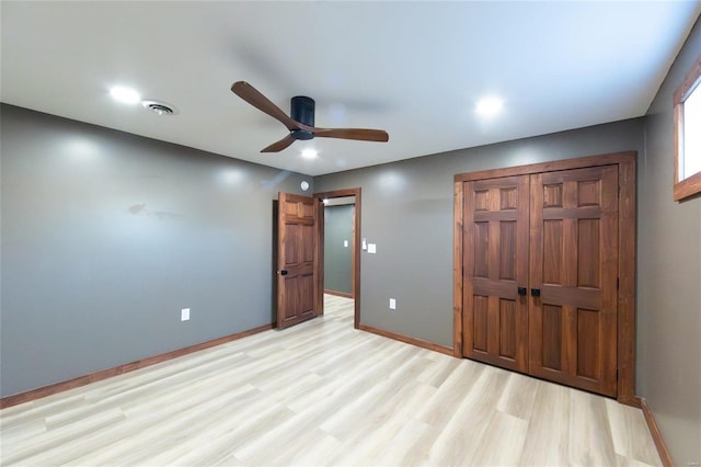 unfurnished bedroom featuring visible vents, light wood-style flooring, a ceiling fan, a closet, and baseboards