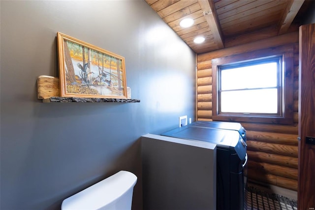 bathroom featuring beamed ceiling, toilet, wood ceiling, and independent washer and dryer