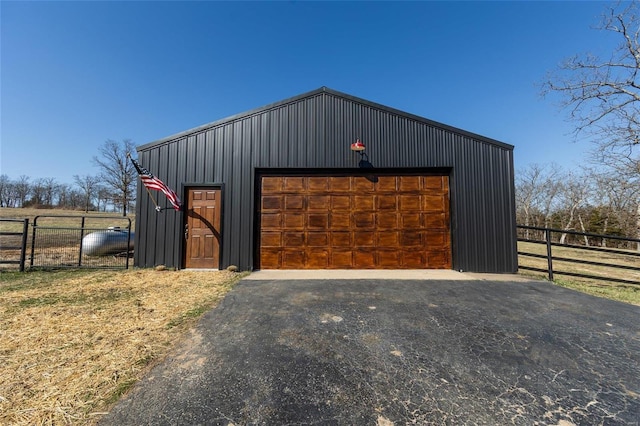 view of outbuilding featuring an outbuilding, fence, and driveway