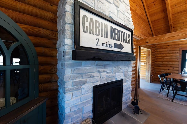 details with beamed ceiling, wood ceiling, a stone fireplace, wood finished floors, and log walls