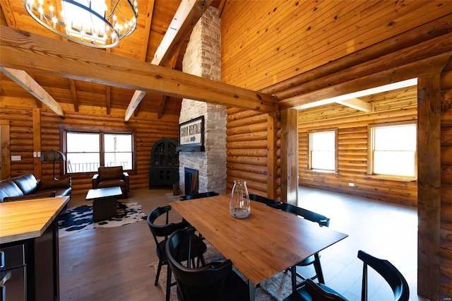 dining space featuring beam ceiling, a stone fireplace, high vaulted ceiling, and hardwood / wood-style flooring