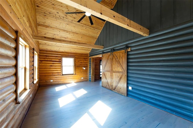 interior space with beamed ceiling, wood ceiling, a barn door, wood finished floors, and high vaulted ceiling