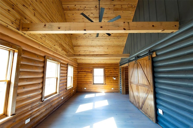 empty room with light wood-type flooring, a barn door, beam ceiling, high vaulted ceiling, and a ceiling fan