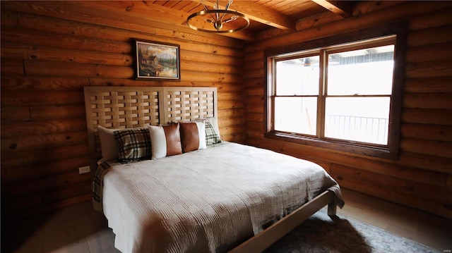 bedroom featuring beamed ceiling, wooden ceiling, and log walls