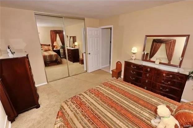 bedroom with light carpet and a closet