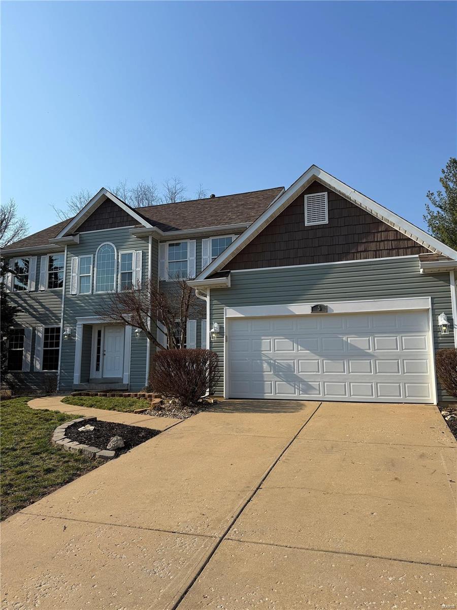 view of front of home with concrete driveway and a garage