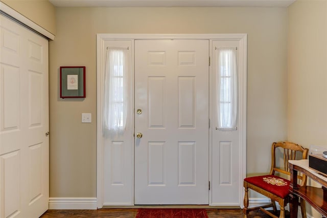 foyer entrance with a healthy amount of sunlight, dark wood-type flooring, and baseboards