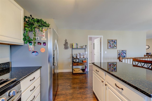 kitchen featuring white cabinetry, stainless steel appliances, dark wood-type flooring, and dark stone counters