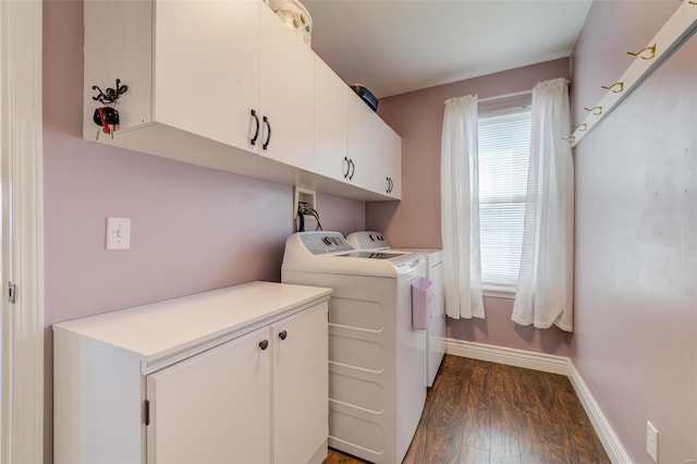 clothes washing area with baseboards, cabinet space, dark wood-type flooring, and washing machine and clothes dryer