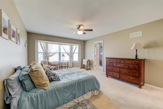 bedroom with a ceiling fan, baseboards, visible vents, and light carpet