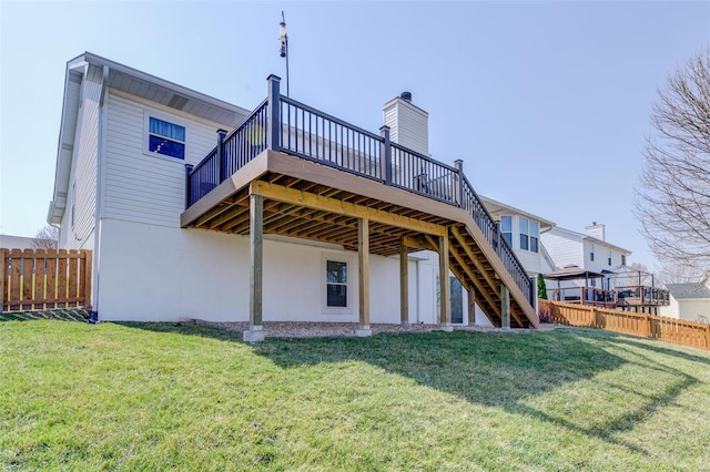 back of house featuring a yard, stairway, a wooden deck, and fence