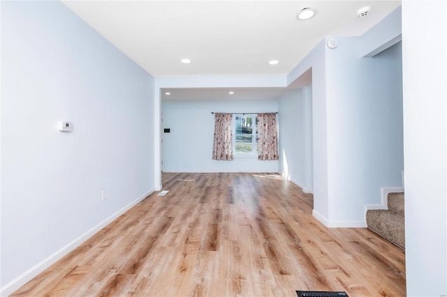 spare room with recessed lighting, stairway, baseboards, and wood finished floors