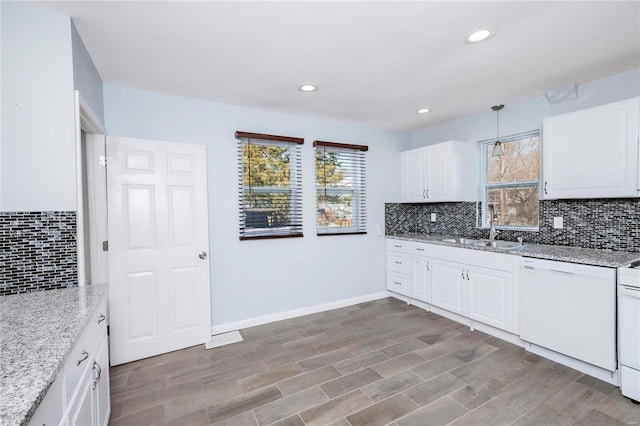 kitchen featuring a sink, white cabinets, decorative backsplash, baseboards, and dishwasher